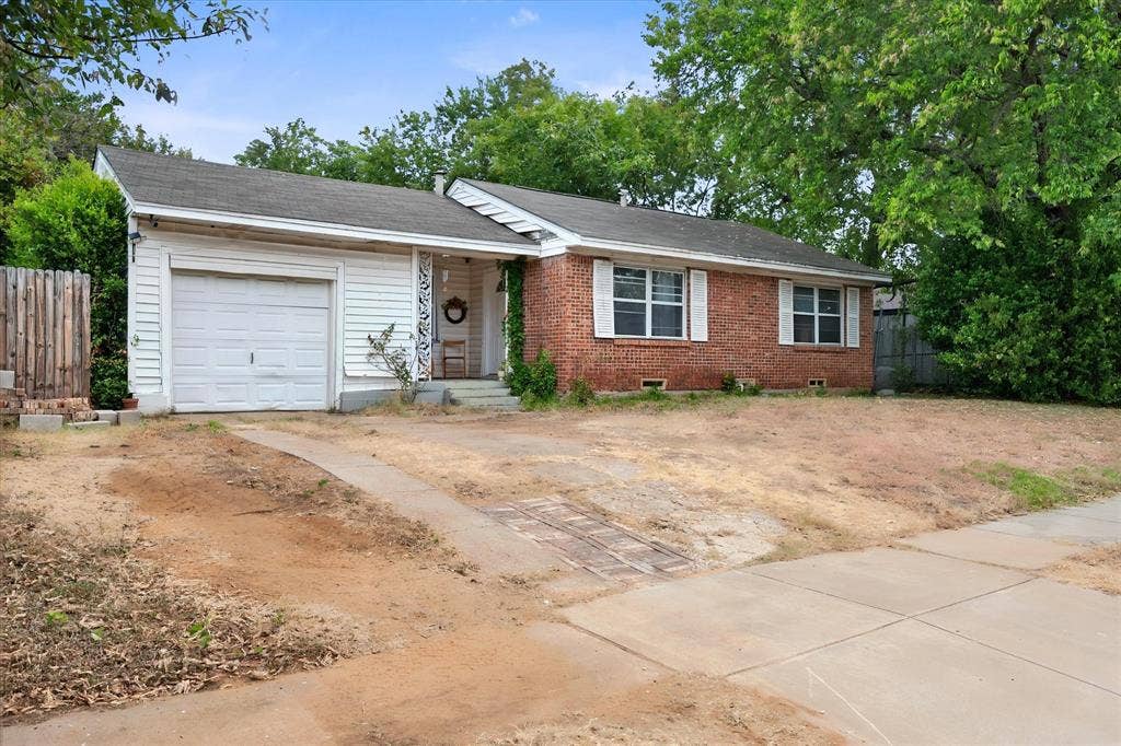 1405 Grace Street, Arlington, TX 76010 Brick and siding exterior featuring a covered entry, attached garage, and multi-pane windows