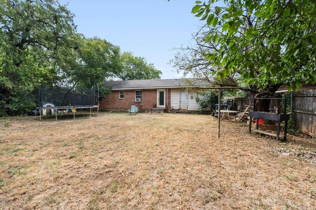 1405 Grace Street, Arlington, TX 76010 Expansive backyard featuring mature trees and a privacy fence