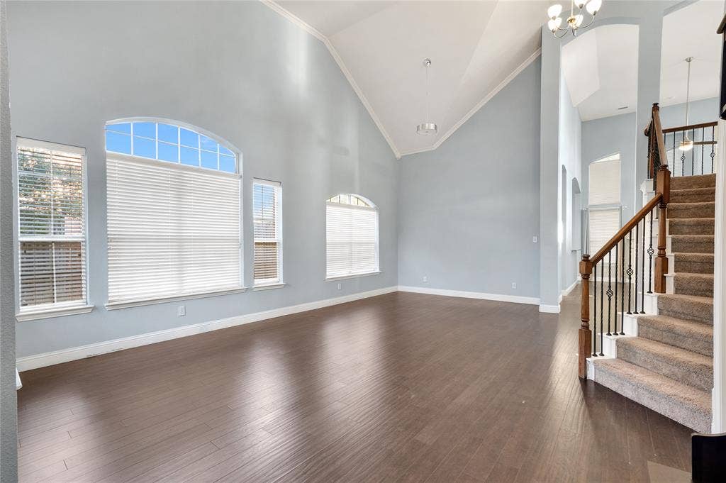 2106 Hillside Drive, Rowlett, TX 75088 Expansive formal living and dining area featuring soaring ceilings, oversized windows, abundant natural light, and an elegant staircase.