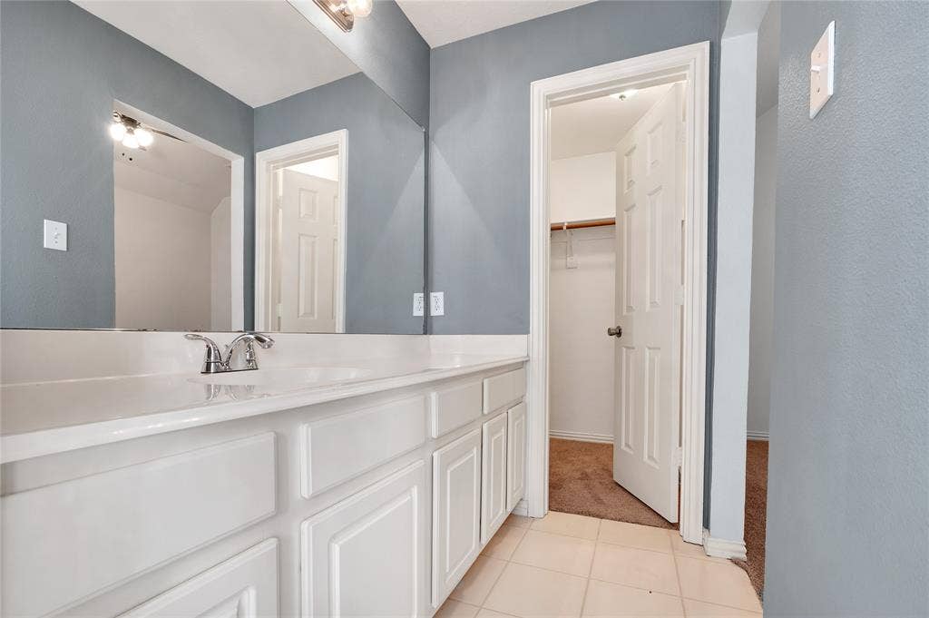2106 Hillside Drive, Rowlett, TX 75088 Spacious bathroom featuring an extended vanity with ample storage, a large mirror, and convenient access to the walk-in closet.