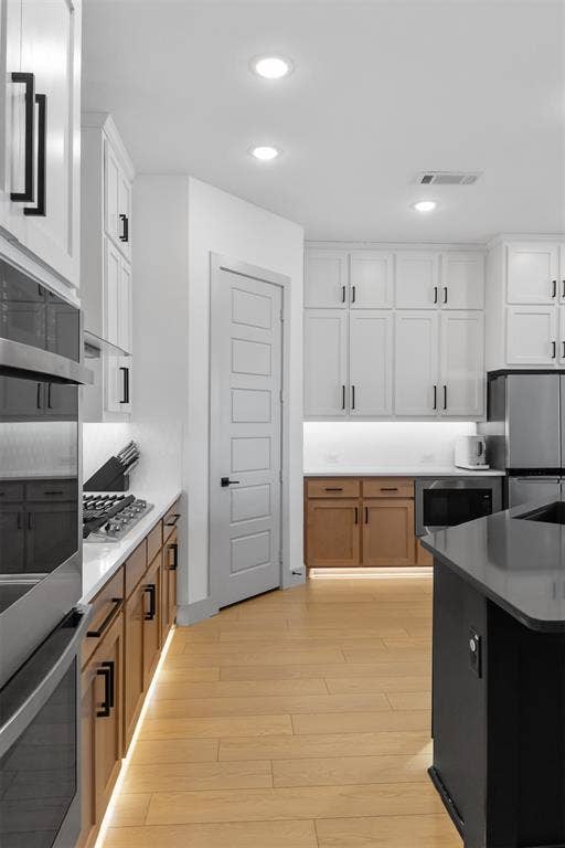 2308 Clancy Drive, Northlake, TX 76247 Kitchen featuring light wood-finish flooring, white upper cabinetry, two-tone lower cabinetry, and recessed lighting