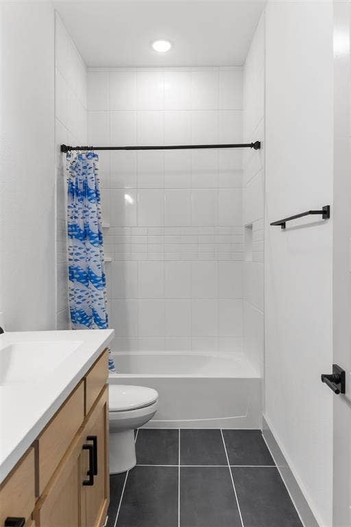 2308 Clancy Drive, Northlake, TX 76247 3rd bathroom with built-in bathtub with white tile surround, dark tile flooring, and a light wood-finish vanity with a white countertop
