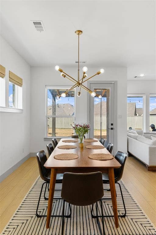 2308 Clancy Drive, Northlake, TX 76247 Bright interior space with wood-finish flooring, a contemporary gold-finish chandelier, and multiple large windows