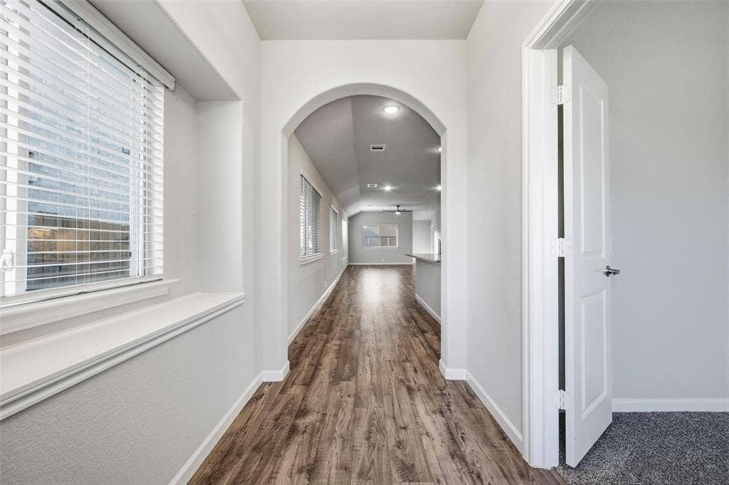 4425 Ridgehurst Lane, Fort Worth, TX 76036 Bright hallway featuring arched architectural details, wood-finish flooring, recessed lighting, and white painted walls with clean sight lines throughout the space