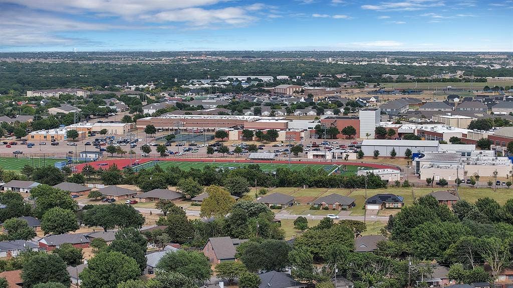 Expansive neighborhood with mature trees, residential properties, and institutional buildings