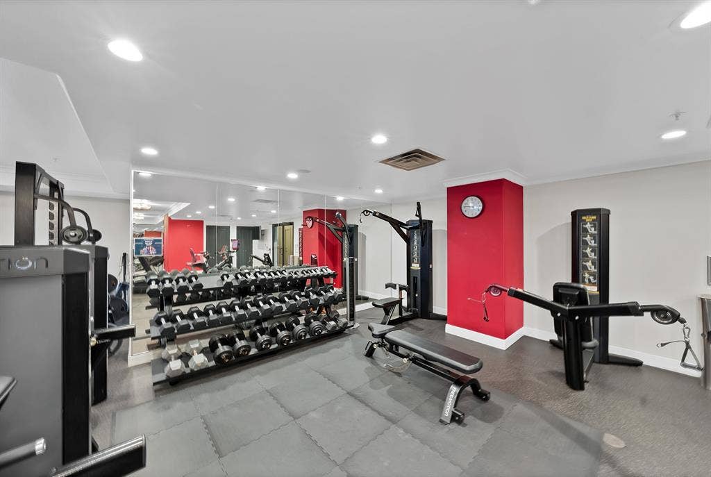 330 Las Colinas Boulevard E, #338, Irving, TX 75039 Fitness center with mirrored wall, recessed lighting, red accent walls, and cushioned flooring