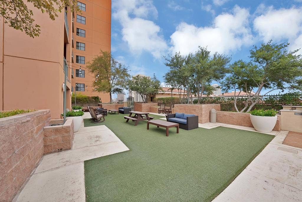 330 Las Colinas Boulevard E, #338, Irving, TX 75039 Expansive outdoor amenity deck featuring artificial turf, concrete paving, and built-in planters with mature trees
