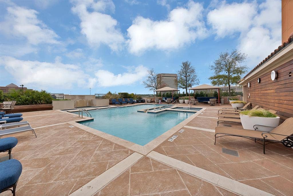 330 Las Colinas Boulevard E, #338, Irving, TX 75039 Rooftop pool deck with a geometric pool, two integrated spas, stamped concrete surfacing, and a wood-slat exterior wall