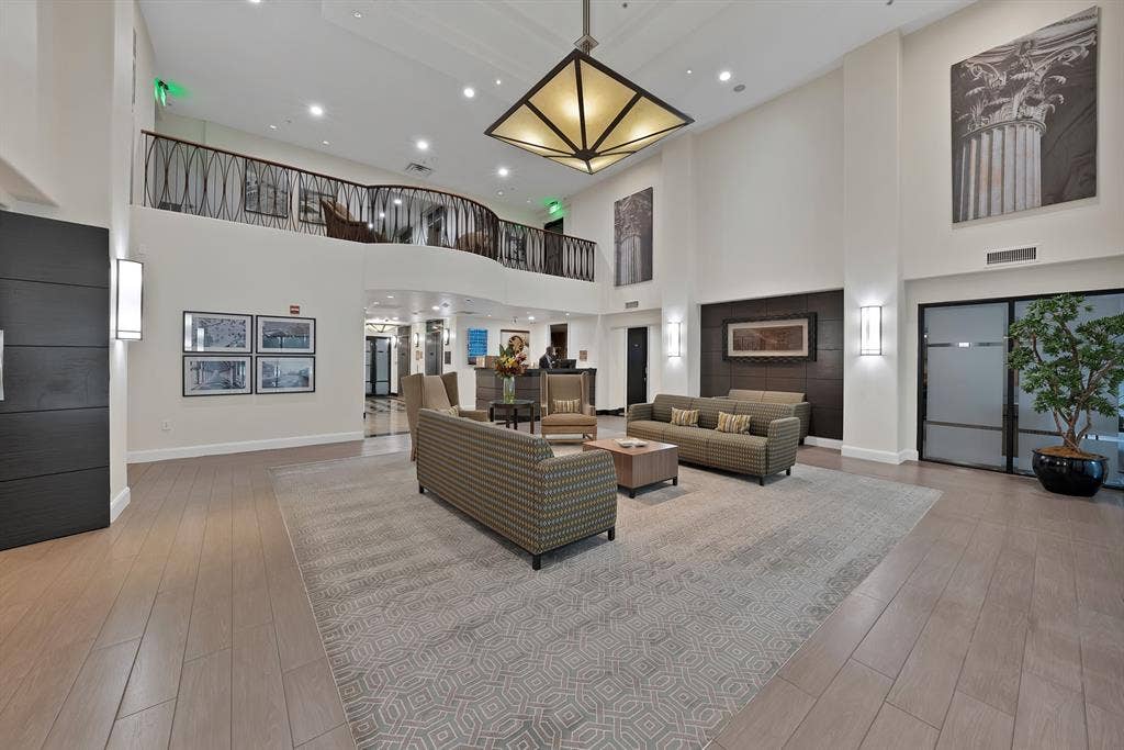 330 Las Colinas Boulevard E, #338, Irving, TX 75039 Two-story foyer with high ceilings, wood-finish flooring, and a decorative wrought-iron balcony