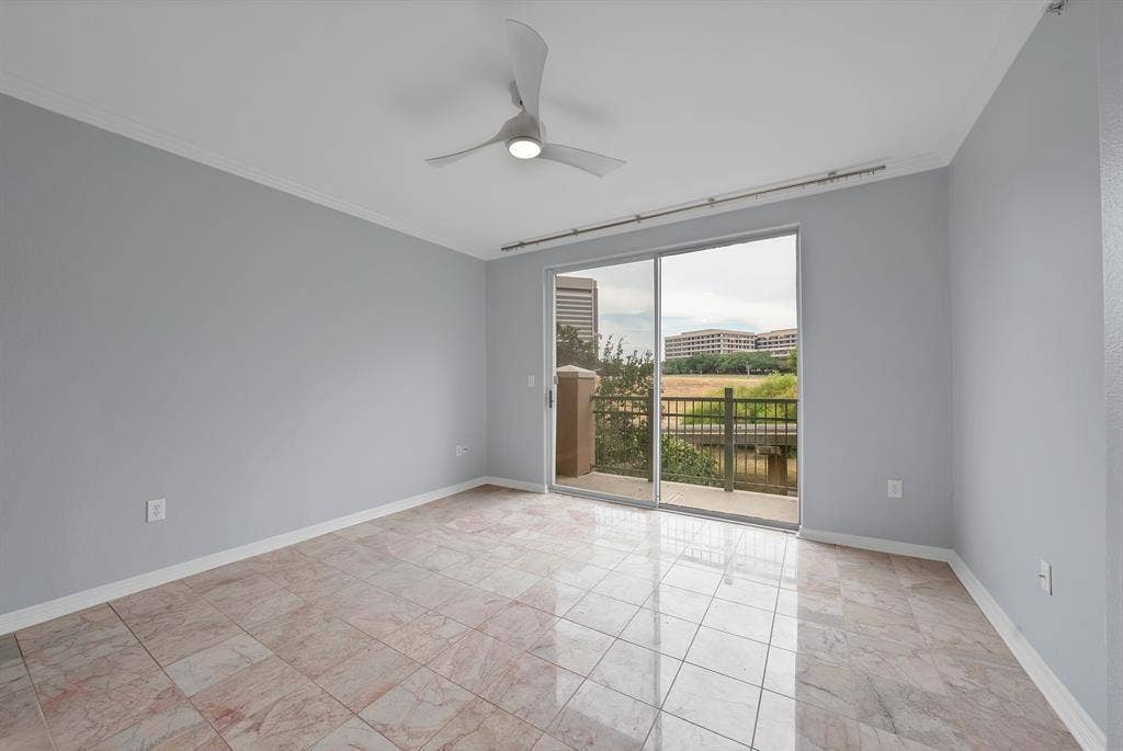 330 Las Colinas Boulevard E, #338, Irving, TX 75039 Spacious room featuring tile flooring, light gray walls, a ceiling fan with integrated lighting, and a sliding glass door leading to a balcony with metal railings