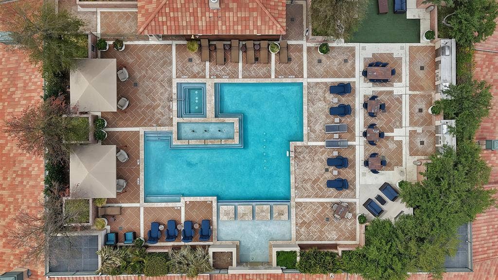 330 Las Colinas Boulevard E, #338, Irving, TX 75039 Expansive outdoor common area featuring a multi-level swimming pool, integrated spa, tiled patio, and lush perimeter landscaping