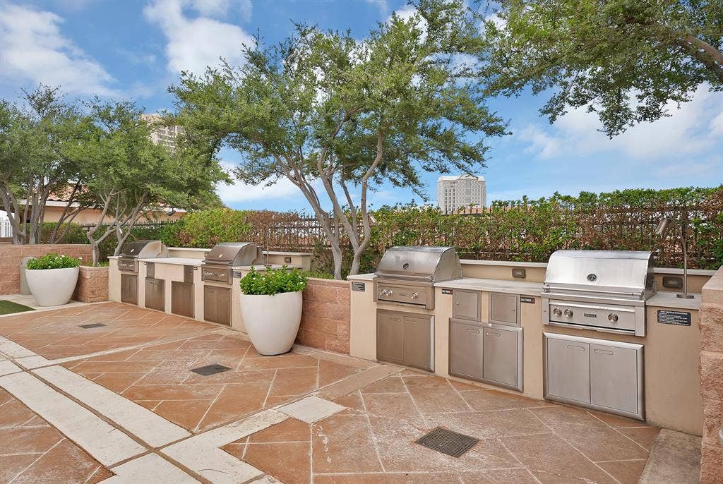 330 Las Colinas Boulevard E, #338, Irving, TX 75039 Expansive outdoor cooking area featuring multiple built-in stainless steel grills, integrated cabinetry, and stone countertops