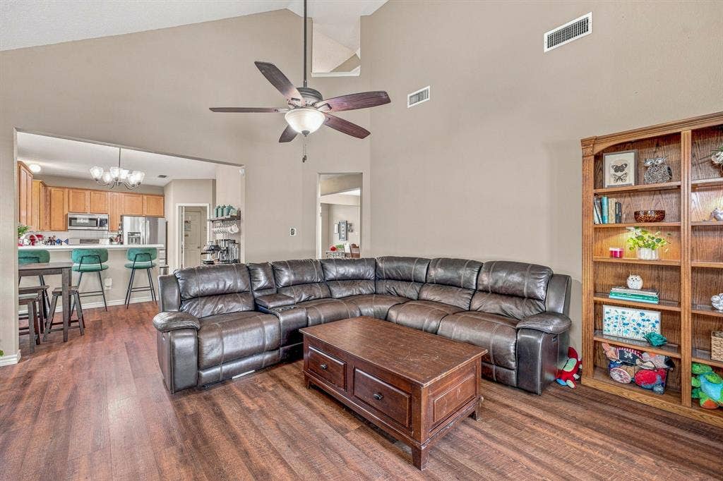 6913 Chaco Trail, Fort Worth, TX 76137 Vaulted ceiling, wood-finish flooring, built-in shelving, ceiling fan, and recessed kitchen with wood cabinetry