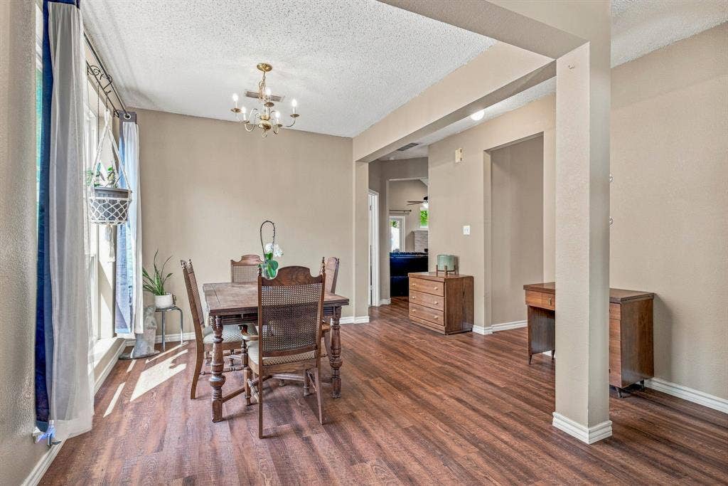 6913 Chaco Trail, Fort Worth, TX 76137 Wood-finish flooring throughout, featuring a classic chandelier, open doorways, and neutral wall tones