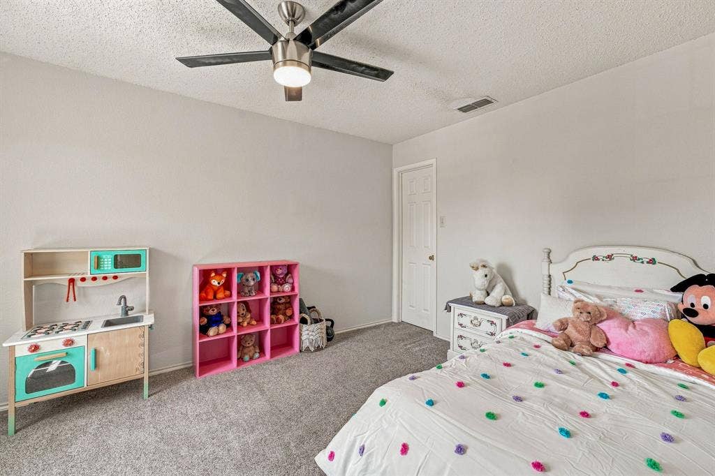 6913 Chaco Trail, Fort Worth, TX 76137 Carpeted flooring, ceiling fan with integrated lighting, white interior door with a round knob, textured ceiling, and light-colored wall paint