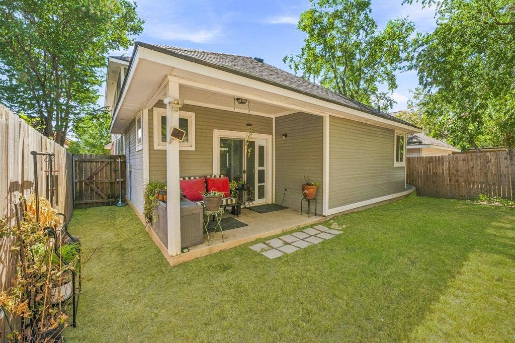 6913 Chaco Trail, Fort Worth, TX 76137 Expansive backyard featuring a covered patio, sliding glass door, board and batten siding, privacy fencing, and stone paver accents