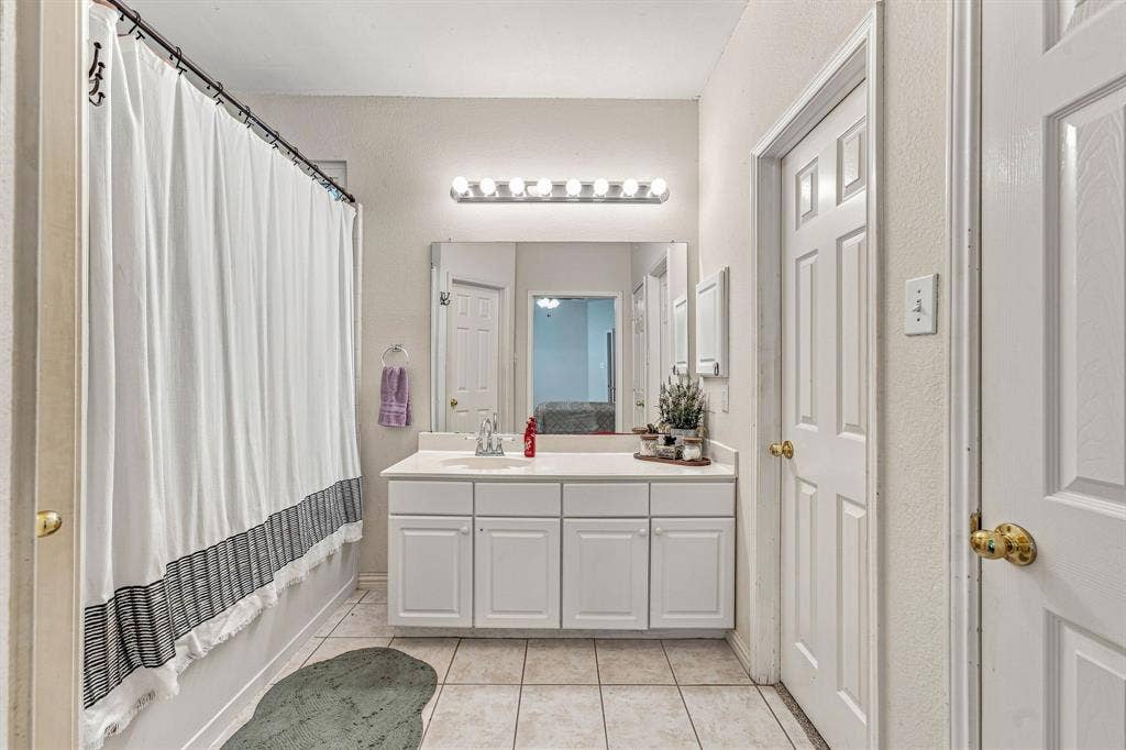 6913 Chaco Trail, Fort Worth, TX 76137 Single vanity with ample counter space, built-in cabinetry, and overhead lighting