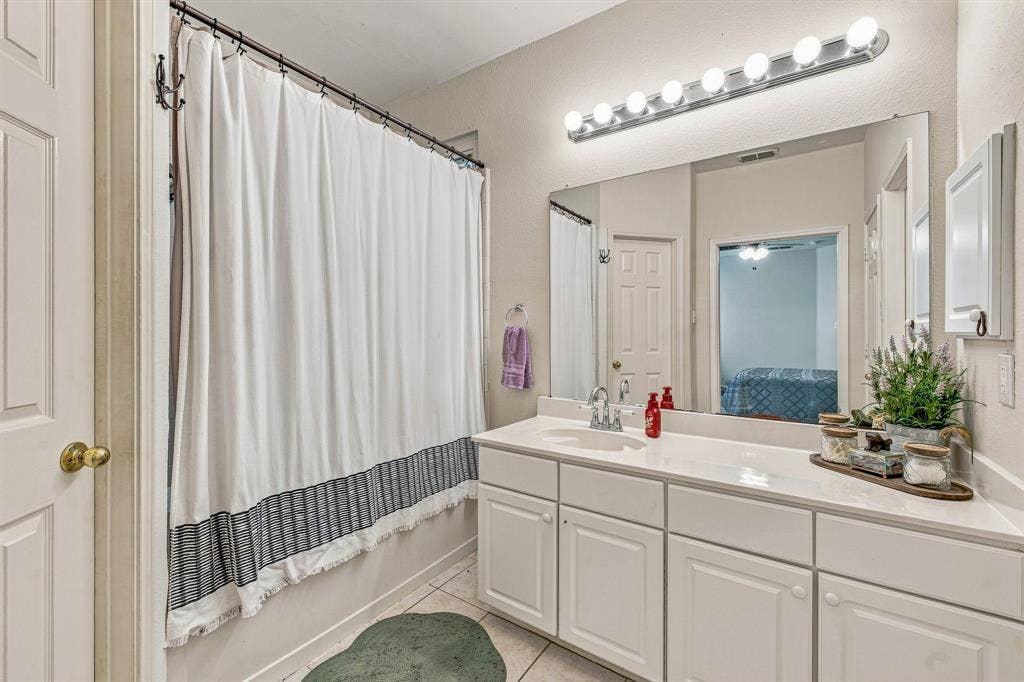 6913 Chaco Trail, Fort Worth, TX 76137 Vanity with an integrated sink, white cabinetry, and a large wall-mounted mirror