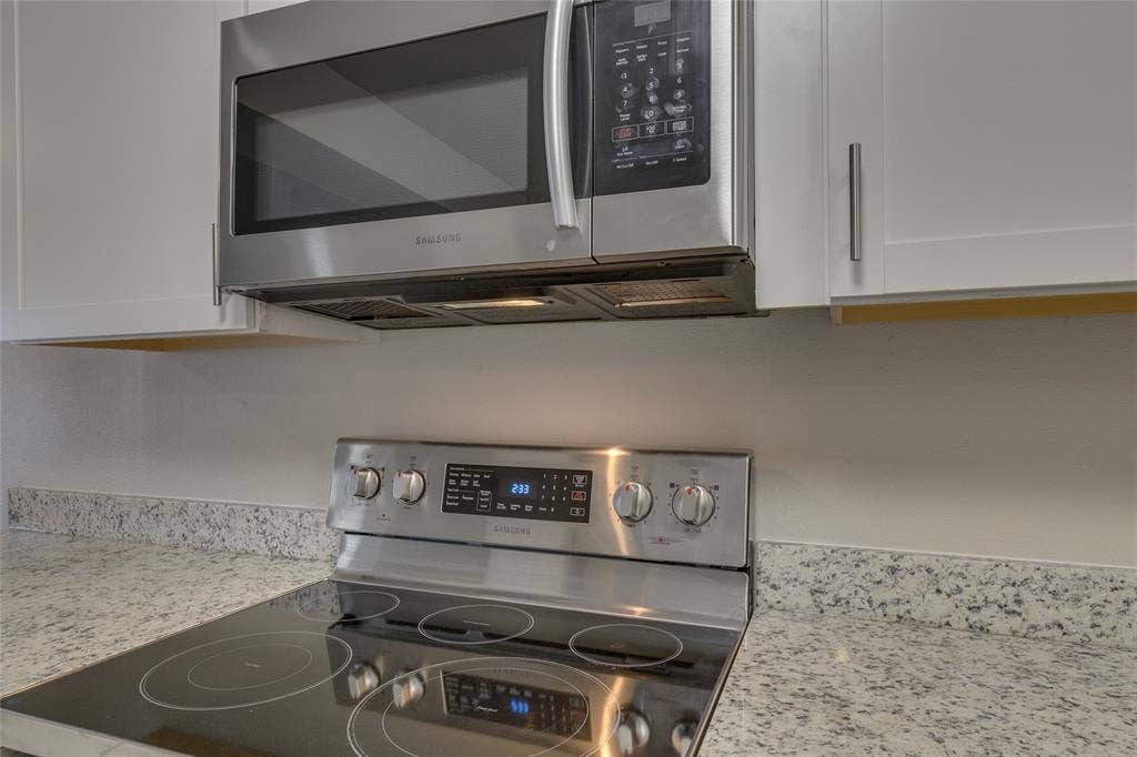 157 Harbor Drive, Gun Barrel City, TX 75156 Kitchen view of appliances with stainless steel finishes, light stone countertops, and white cabinetry