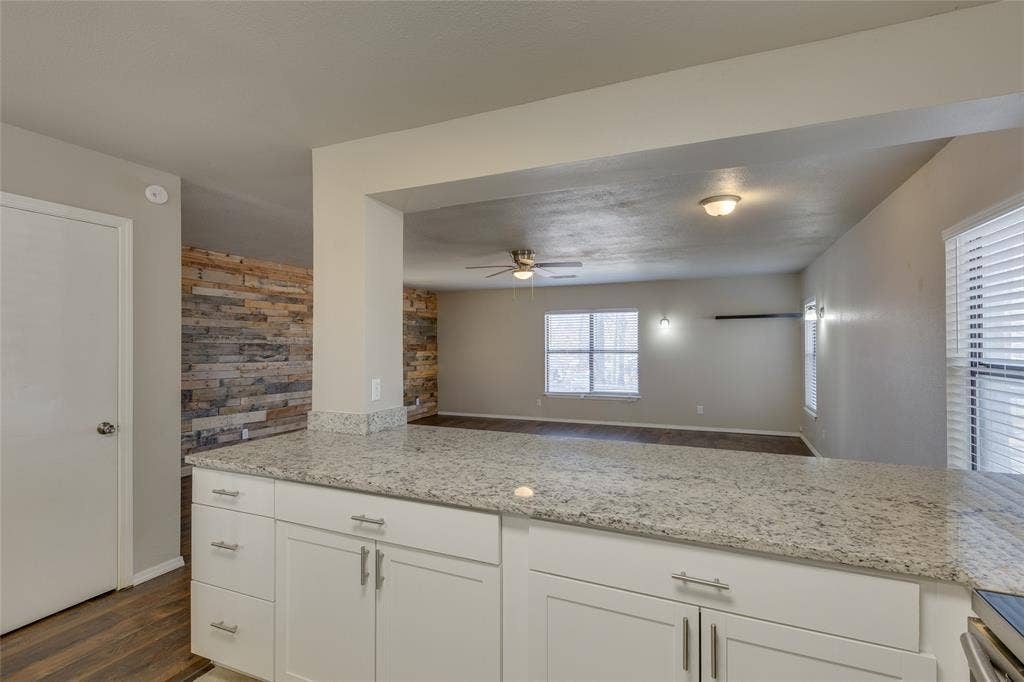 157 Harbor Drive, Gun Barrel City, TX 75156 Kitchen featuring dark wood-type flooring, white cabinetry, light stone countertops, and open floor plan