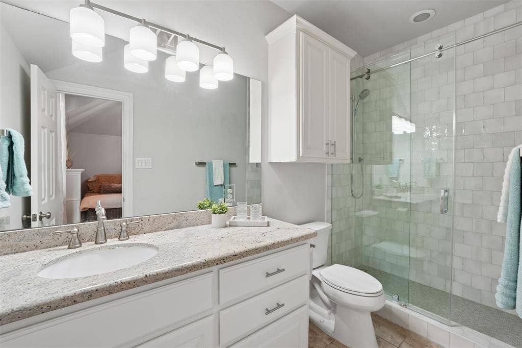 1712 Singletree Court, McKinney, TX 75072 Updated upstairs bathroom features a clean, neutral design and functional vanity space.