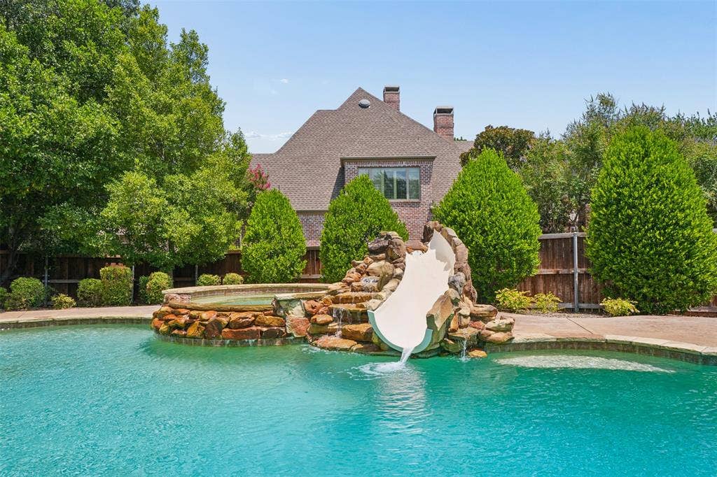 1712 Singletree Court, McKinney, TX 75072 Resort-style pool features a dramatic rock-integrated waterslide, spa and mature landscaping.