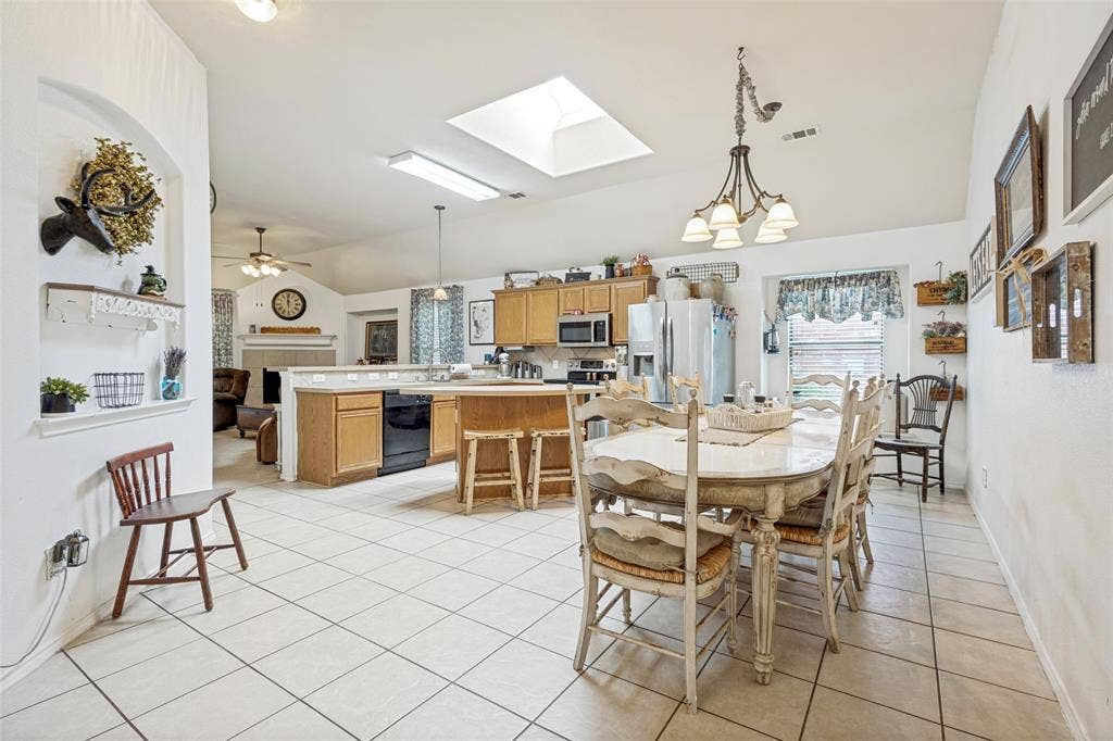 2118 Hanakoa Falls Drive, Anna, TX 75409 Kitchen featuring light wood cabinetry,large dining area and a skylight for extra light.