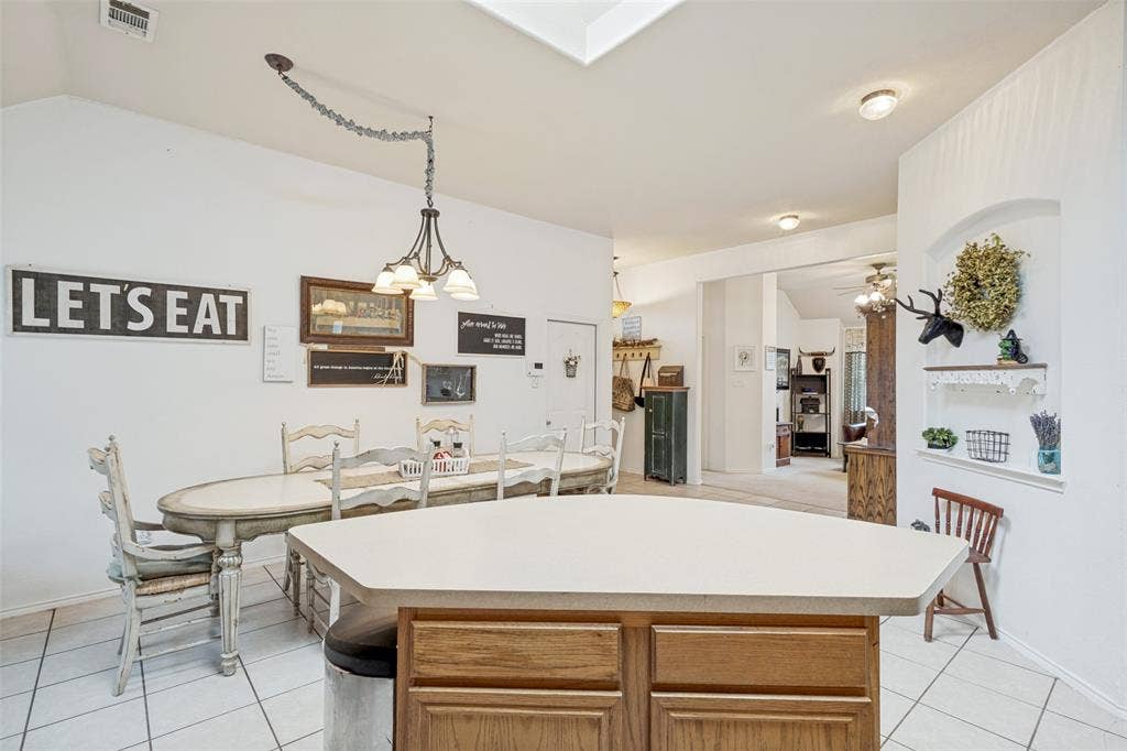 2118 Hanakoa Falls Drive, Anna, TX 75409 Kitchen island with light-toned countertop and wood-finish cabinetry