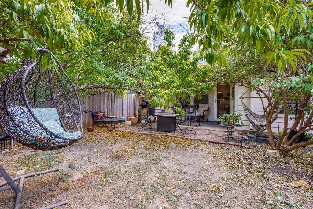 2118 Hanakoa Falls Drive, Anna, TX 75409 Expansive backyard featuring a brick paver patio, a white wood-paneled exterior, and mature trees