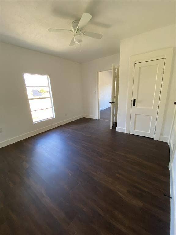 801 Walnut Street, Trinidad, TX 75163 Dark wood-finish flooring, white walls, ceiling fan, and white trim throughout