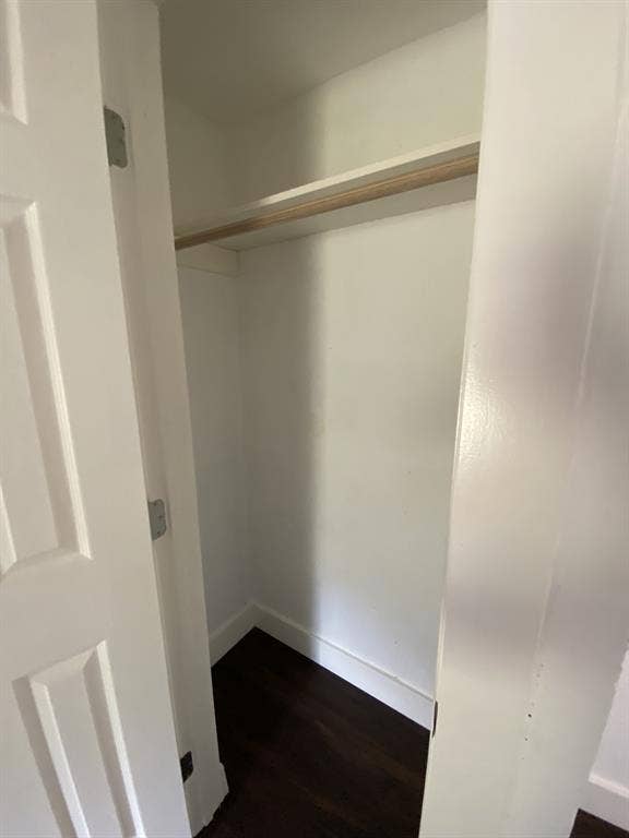 801 Walnut Street, Trinidad, TX 75163 White closet interior with a single shelf, wood-finish hanging rod, and dark wood-finish flooring