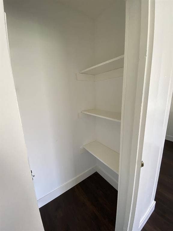 801 Walnut Street, Trinidad, TX 75163 White shelving system with three levels, dark wood-finish flooring, and white walls