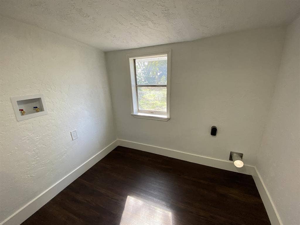 801 Walnut Street, Trinidad, TX 75163 Room featuring wood-finish flooring, white walls, and a window with white trim