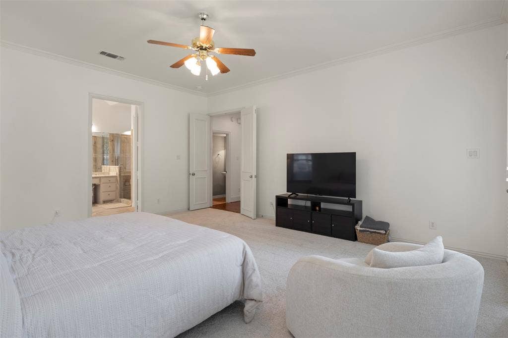 Recessed ceiling fan with wood-finish blades, white crown molding, and light-toned carpeting