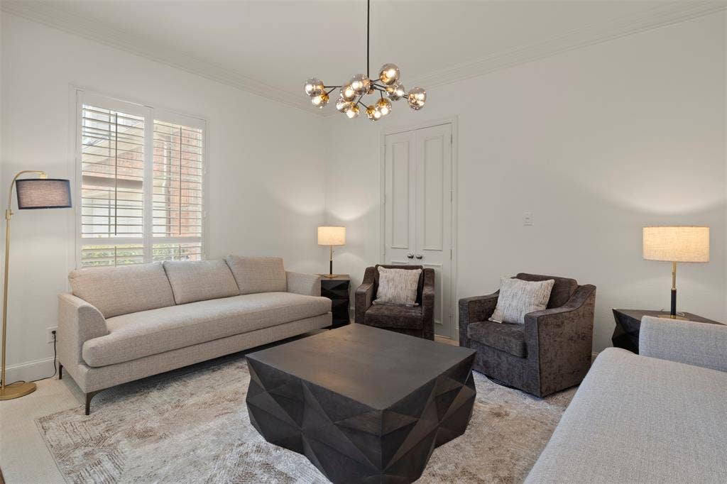 White walls with crown molding, plantation shutters, and a contemporary chandelier