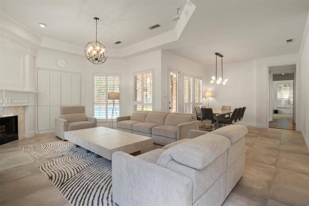 Spacious living area featuring a fireplace with a mantel, built-in cabinetry, and tile flooring