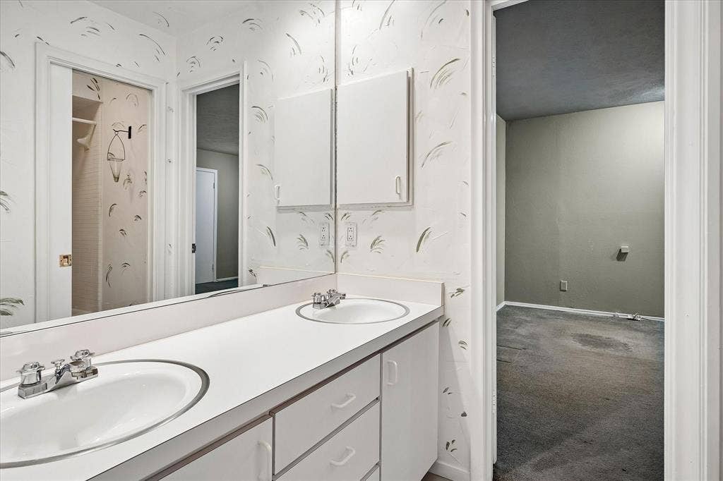 4108 Myerwood Lane, Dallas, TX 75244 Dual-sink Jack-and-Jill bathroom connecting two bedrooms, with a separate shower.