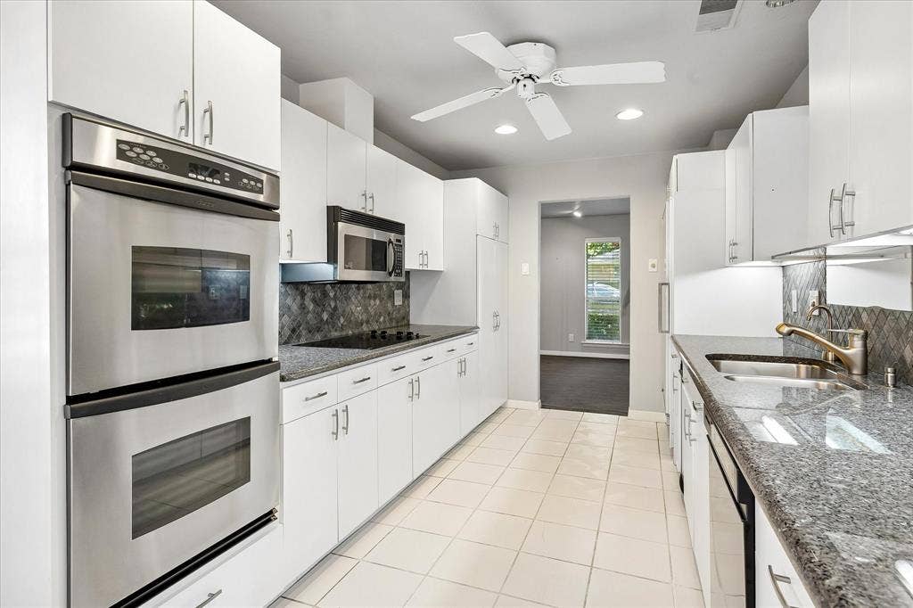 4108 Myerwood Lane, Dallas, TX 75244 Long galley kitchen with abundant cabinetry and granite countertops throughout.