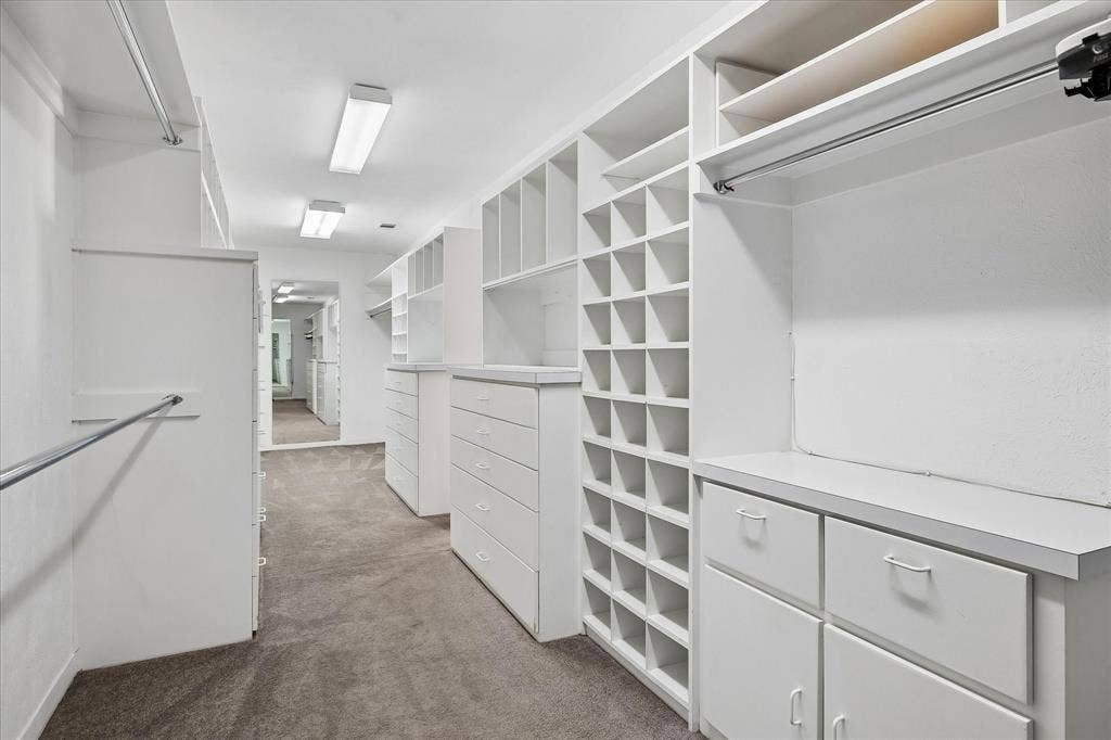 4108 Myerwood Lane, Dallas, TX 75244 Massive Primary custom walk-in closet with built-in drawers, shelving, and cubby storage.