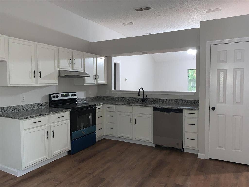 120 Plumthicket Lane, Trinidad, TX 75163 Kitchen featuring wood-finish flooring, white cabinetry with black hardware, granite-look countertops, and stainless steel appliances