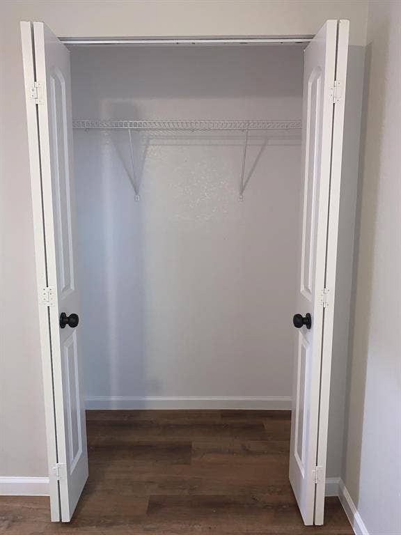 120 Plumthicket Lane, Trinidad, TX 75163 Closet featuring bifold doors with black hardware, wood-finish flooring, and a wire shelving system