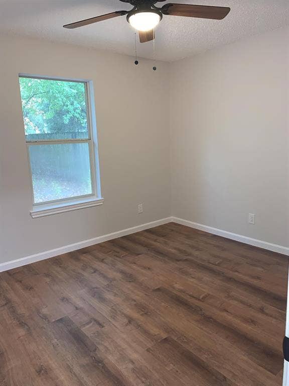 120 Plumthicket Lane, Trinidad, TX 75163 Wood-finish flooring with white trim, a double-hung window, and a ceiling fan with integrated lighting