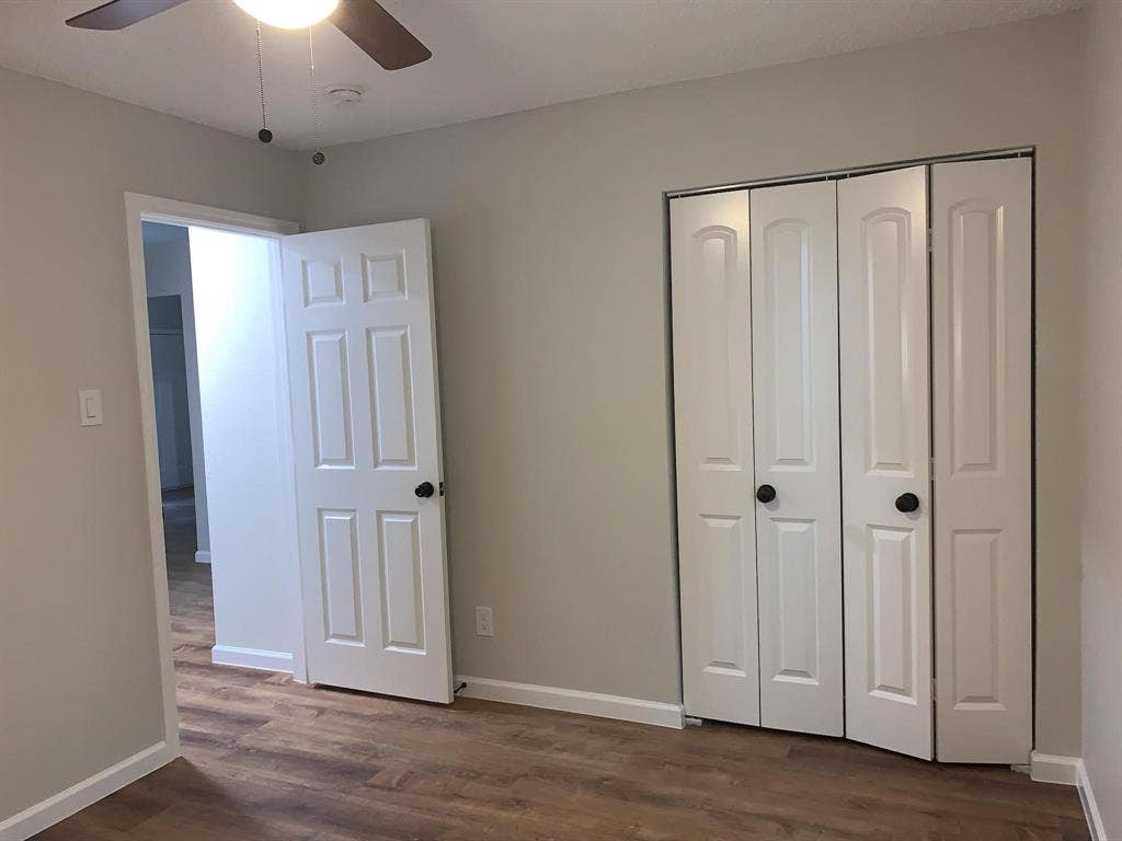 120 Plumthicket Lane, Trinidad, TX 75163 Wood-finish flooring, ceiling fan with integrated lighting, white paneled doors, and bi-fold closet doors with black hardware