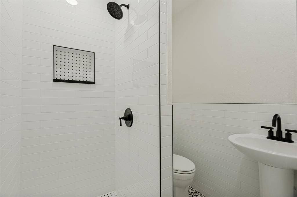 4316 Springbranch Drive, Benbrook, TX 76116 White subway tile shower with a matte black rain shower head and built-in niche
