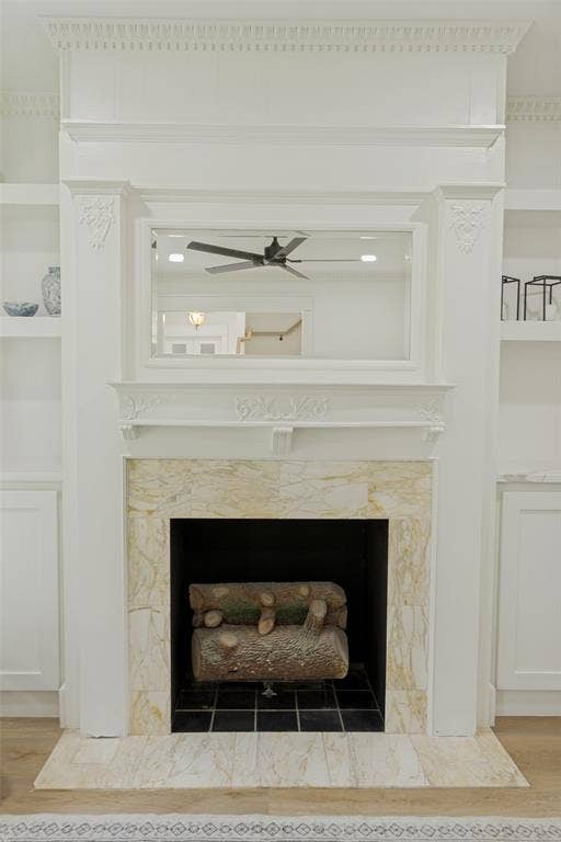 4316 Springbranch Drive, Benbrook, TX 76116 Fireplace with a stone surround, stone hearth, and a mantel, flanked by built-in shelving and cabinetry