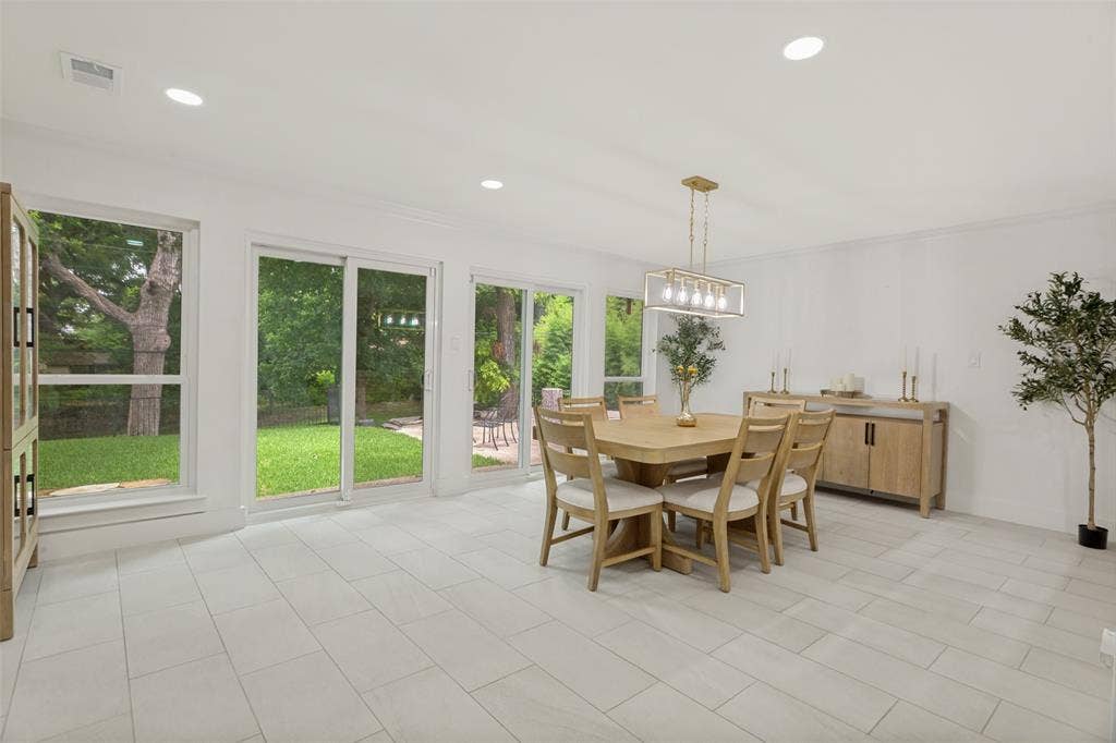 4316 Springbranch Drive, Benbrook, TX 76116 Bright, open dining area flooded with natural light through expansive multi-panel glass doors and windows overlooking manicured grounds