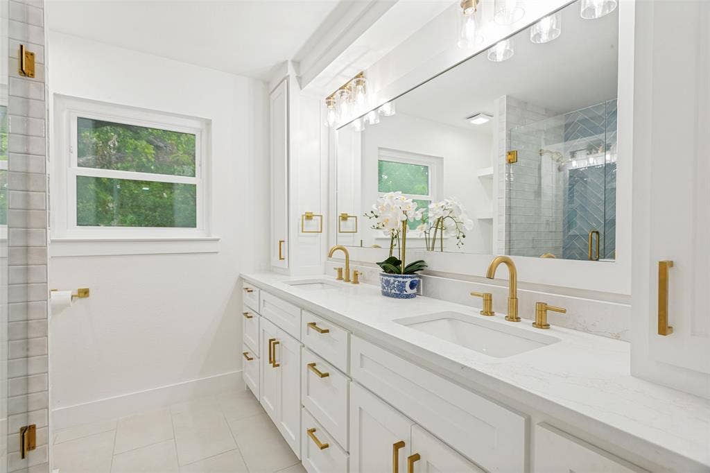 4316 Springbranch Drive, Benbrook, TX 76116 Dual vanity with white cabinetry and integrated sinks, complemented by gold-finish fixtures and hardware