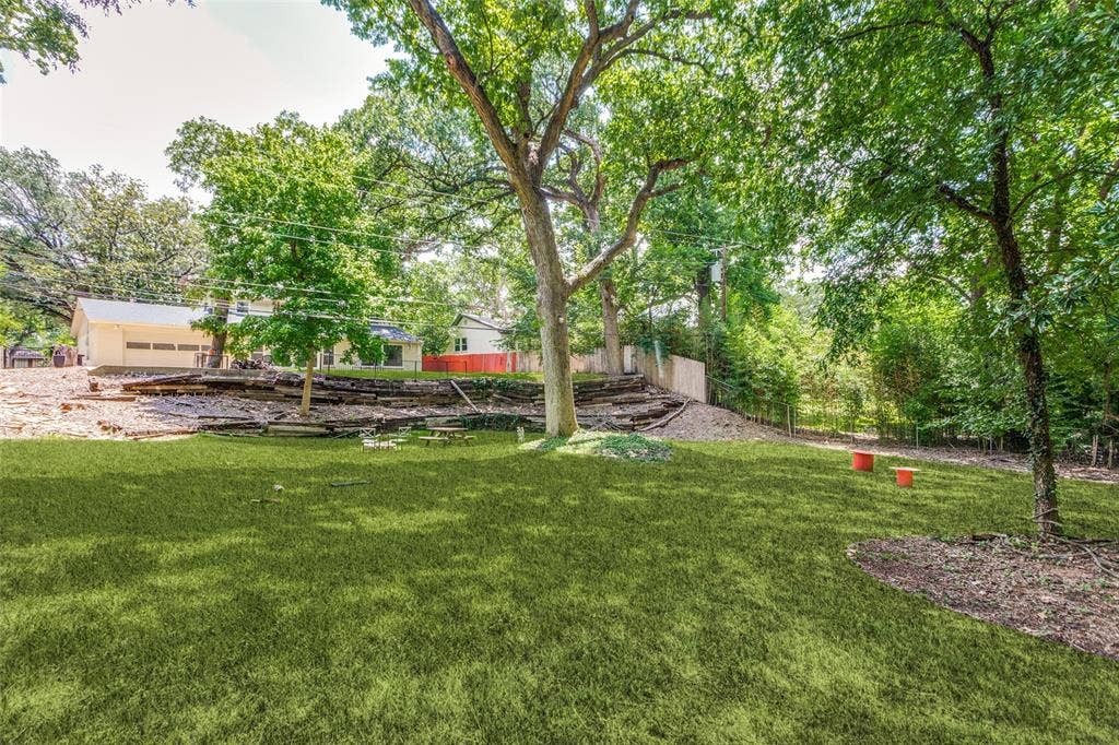 4316 Springbranch Drive, Benbrook, TX 76116 Expansive backyard featuring a manicured lawn, mature trees, and a terraced hillside