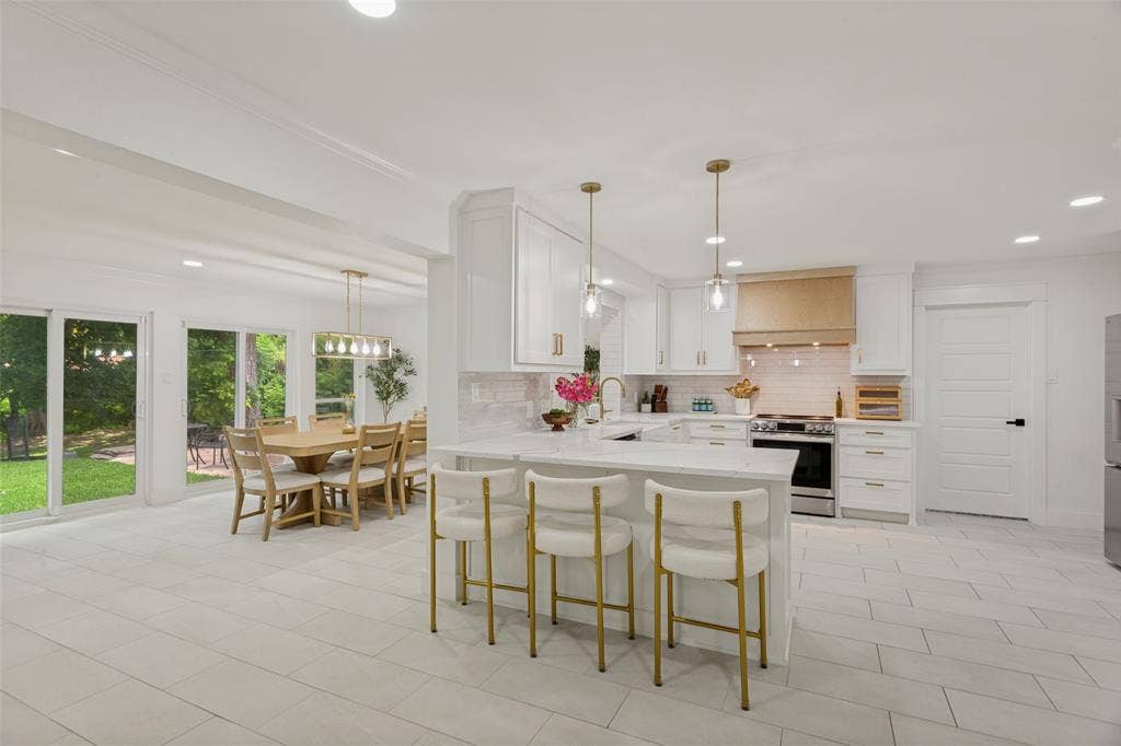 4316 Springbranch Drive, Benbrook, TX 76116 Open-concept kitchen with white cabinetry, tile backsplash, stainless steel appliances, and a central island with pendant lighting