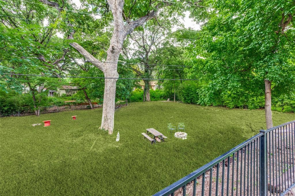 4316 Springbranch Drive, Benbrook, TX 76116 Expansive lawn area with mature trees and a black metal railing